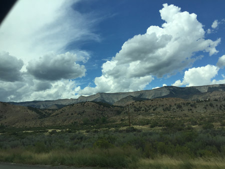 Exploring the Dramatic Landscape of Rugged Mountains Under a Vast, Cloudy Sky in the Afternoonの写真素材