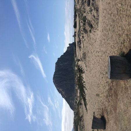 Scenic View of Morro Rock Surrounded by Sandy Landscape Under a Blue Sky at Middayの写真素材