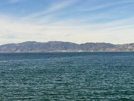 Sparkling Blue Waves Near Coastal Mountains on a Sunny Afternoonの写真素材