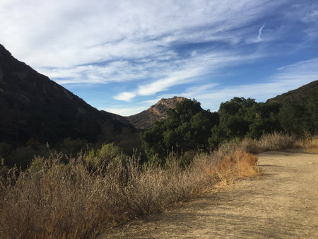 Breathtaking View of Rugged Hills Under a Blue Sky During a Peaceful Afternoon Strollの写真素材