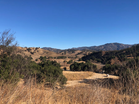 Breathtaking View of Rolling Hills Under a Clear Blue Sky in a Tranquil Countryside Landscapeの写真素材