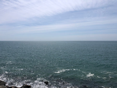 Calm Sea Under Bright Sky on a Peaceful Day by the Shore Invites Relaxation and Reflectionの写真素材