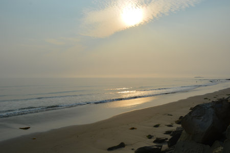 Morning Light Paints a Tranquil Beach With Soft Waves and a Serene Horizon at Dawnの写真素材