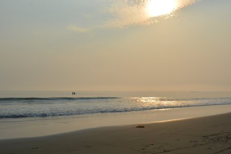 Sunset Casts a Warm Glow Over the Tranquil Beach With Calm Waves Lapping at the Shoreの写真素材