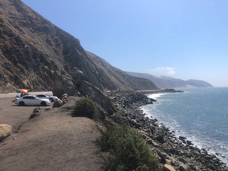 Scenic Coastal Drive Reveals the Beauty of the Pacific Shore Under a Bright Blue Skyの写真素材