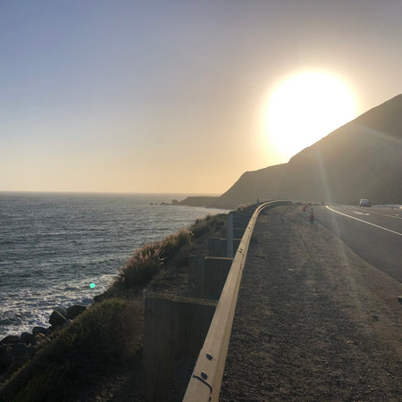 Sunset View Over the Ocean Along a Scenic Coastal Highway at Golden Hourの写真素材