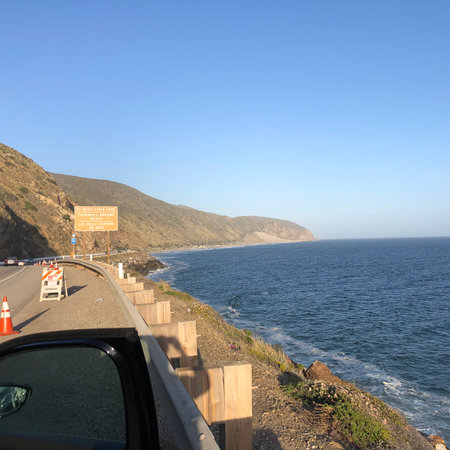 Scenic Coastal Drive Along the Winding Road With Views of the Ocean and Mountains at Sunsetの写真素材