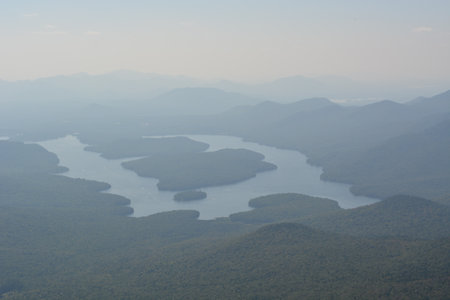 Scenic Overlook of a Winding Lake Surrounded by Misty Mountains in the Early Morning Light