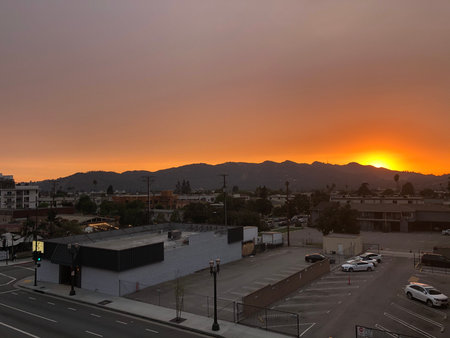 Stunning Sunset Over the Hills, Casting a Warm Glow on the Cityscape Belowの写真素材