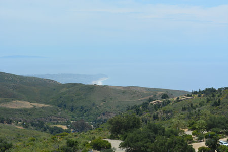 Expansive View of Coastal Hills and Serene Ocean Horizon Under a Blue Skyの写真素材