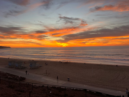 Stunning Sunset Illuminates the Beach With Vibrant Colors and Tranquil Waves at Duskの写真素材