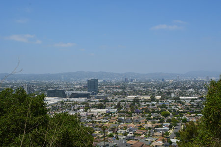 Vibrant Cityscape View From a Hillside Overlooking a Bustling Urban Landscape in Bright Daylightの写真素材
