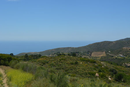 Scenic Coastal View From a Hillside With Lush Greenery and Clear Blue Sky, Capturing Nature's Beauty and Tranquillityの写真素材