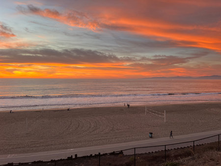 Vibrant Sunset Paints the Sky Above the Beach With Colorful Hues During a Serene Evening Stroll by the Oceanの写真素材
