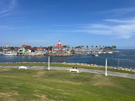 Scenic Waterfront View of Marina With Colorful Buildings, Boats, and Palm Trees Under a Bright Blue Skyの写真素材