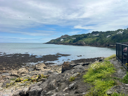 Scenic Coastal View of Rocky Shoreline Under Cloudy Sky in a Tranquil Seaside Locationの写真素材