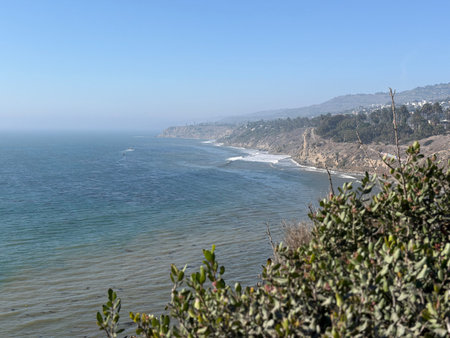 Serene Coastal View Overlooking Tranquil Waves and Rugged Cliffs at Middayの写真素材