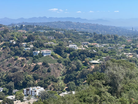 Scenic View of Lush Hills and Homes in Los Angeles on a Sunny Day With Mountains in the Distanceの写真素材