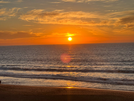 Vibrant Sunset Over the Ocean With Colorful Skies and Gentle Waves at the Beachfront in the Late Eveningの写真素材