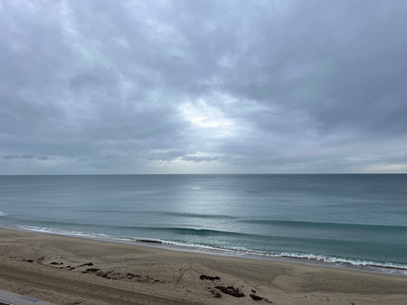 Evening Calm Over the Tranquil Beach With Gentle Waves and a Cloudy Skyの写真素材