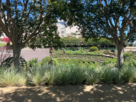 Beautiful Garden View Showcasing Lush Greenery and Intricate Pathways During a Sunny Afternoon at a Public Space in Springtimeの写真素材