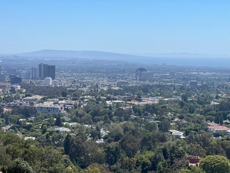 Overlooking a Bustling Cityscape From a Serene Hilltop on a Clear Day Reveals Endless Greenery and Urban Structuresの写真素材