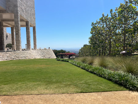 Scenic Garden at a Museum Showcasing Lush Greenery and Vibrant Flowers Under Clear Blue Skiesの写真素材