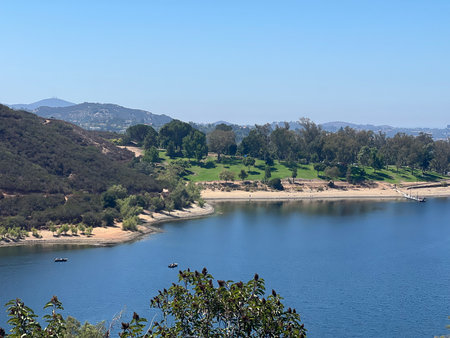 Calm Day by the Lakeside With Boats and Trees Under a Clear Blue Skyの写真素材