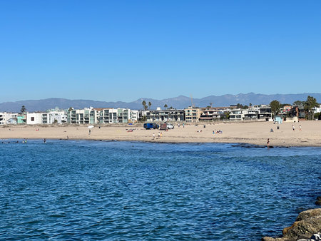 Sunny Beach Scene With People Enjoying the Sand and Ocean in a Coastal Cityの写真素材