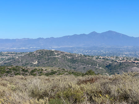 Scenic View of Rolling Hills and Distant Mountains Under Clear Blue Sky in Southern Californiaの写真素材