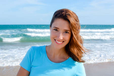 Young attractive woman smiling at the beach, headshotの写真素材