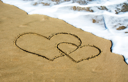 Two hearts drawn on the beach, waves, washの写真素材