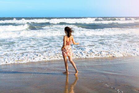 Young attractive woman dancing on the beachの写真素材