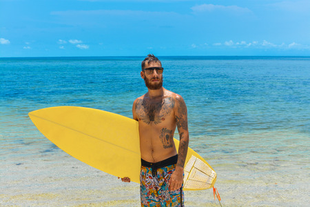 Male surfer waiting for the wave on the beachの写真素材