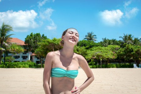 Young woman relaxing and laughing in front of palmsの写真素材