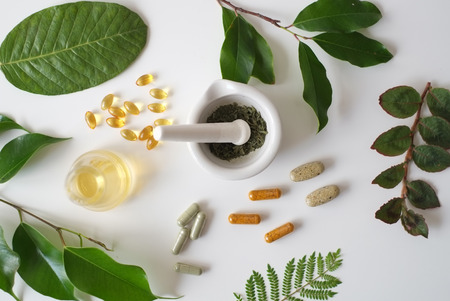 the scientist or doctor make herbal medicine from herb in the laboratory on the table .alternative treatment. show hand and stethoscope. with the bottle container.の写真素材