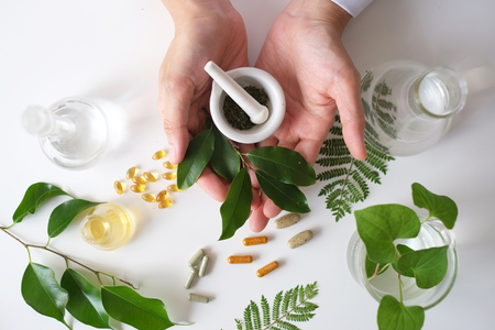 the scientist or doctor make herbal medicine from herb in the laboratory on the table .alternative treatment. show hand and stethoscope. with the bottle container.の写真素材