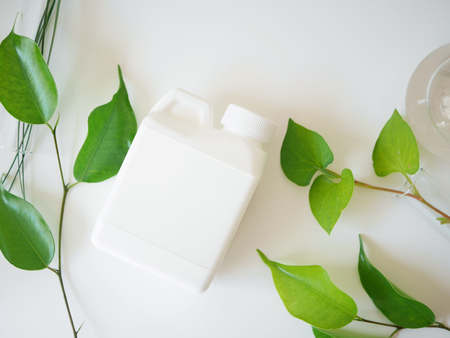 natural skincare bottle container and  organic green leaf , flowers ingredients with the laboratory glassware on white background. Home made remedy and beauty product concept.の写真素材