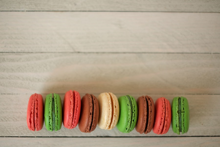 Colorful macaroons or macaron on a white wooden background.Isolated. French delicious pastry.
