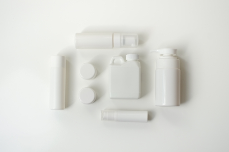 Cosmetic package containers with green leaves, pink salt,herbal . natural  organic beauty product concept mock up. Blank bottle for label own branding skincare. isolated white background.top view.の写真素材