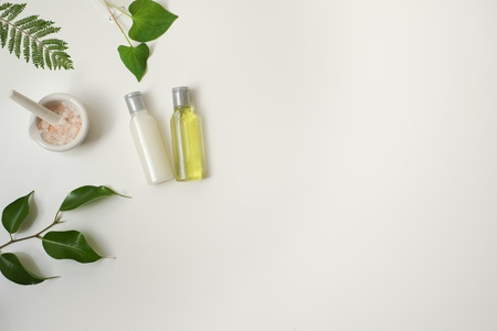 Cosmetic package containers with green leaves, pink salt,herbal . natural  organic beauty product concept mock up. Blank bottle for label own branding skincare. isolated white background.top view.の写真素材