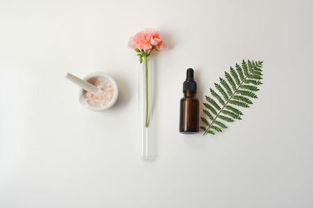 Cosmetic package containers with green leaves, pink salt,herbal . natural  organic beauty product concept mock up. Blank bottle for label own branding skincare. isolated white background.top view.の写真素材