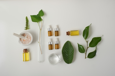 Cosmetic package containers with green leaves, pink salt,herbal . natural  organic beauty product concept mock up. Blank bottle for label own branding skincare. isolated white background.top view.の写真素材