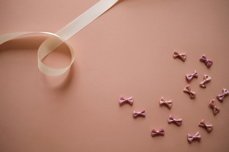 bows background on pink. pastel ribbon and pretty girly. abstract wallpaper pattern.の写真素材