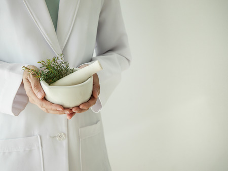scientist or doctor making herbal medicine with herb leaves , capsule, tablets.hands.の写真素材