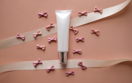 bows background on pink with cosmetic product packaging bottle. pastel ribbon and pretty girly. abstract wallpaper pattern.の写真素材