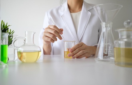 doctor woman scientist making herbal medicine in lab with herb leaves vitamin supplements mineral alternative treatment research.の写真素材