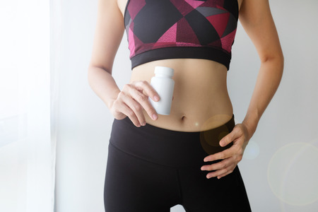healthy woman workout hold vitamin supplement. slim weight lost concept diet nutrition .の写真素材