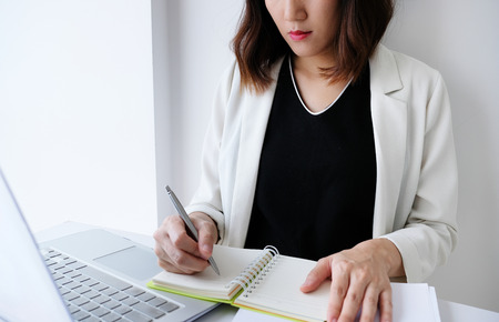 beautiful young business woman working in the office or home with paperwork calculator laptop and...