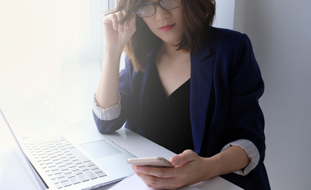 beautiful young business woman working in the office or home with paperwork calculator laptop and computer.の写真素材